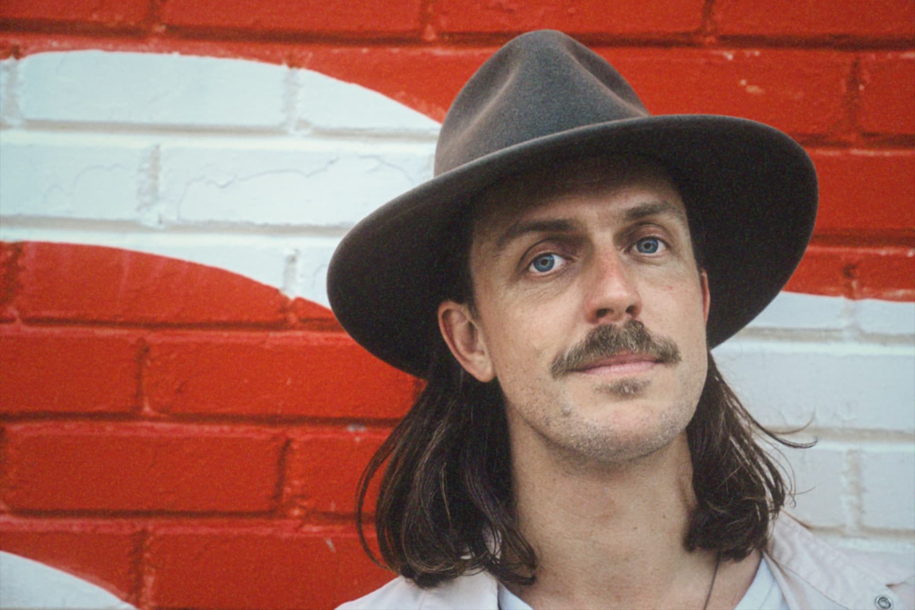 Benjo portrait in a hat against red and white stripes